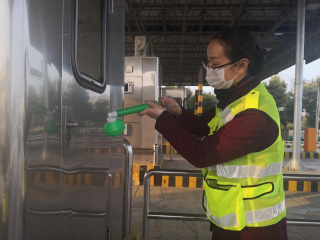 1580884993180088.jpg 界阜蚌公司太和站团员正在认真地给收费亭门把手消毒.jpg