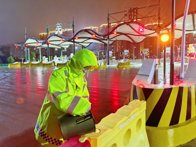 芜湖中心芜湖东站收费班长陈菲因台风“贝碧嘉”来袭，为道口空水马进行灌注，加强其稳定性。.jpg